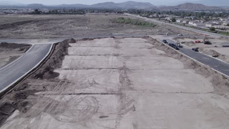 Un-Dron-Se-Desliza-Elegantemente-Sobre-Una-Hilera-De-Lotes-Recién-Aplanados,-Meticulosamente-Preparados-Y-Esperando-El-Próximo-Inicio-De-La-Construcción-De-Viviendas