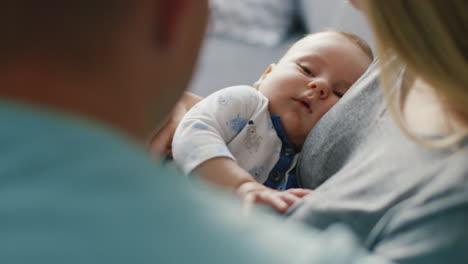 the baby sleeps on the hands of a loving parent view from the back