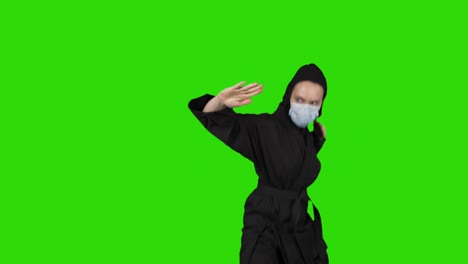 video of woman in black costume ninja dressing medical mask