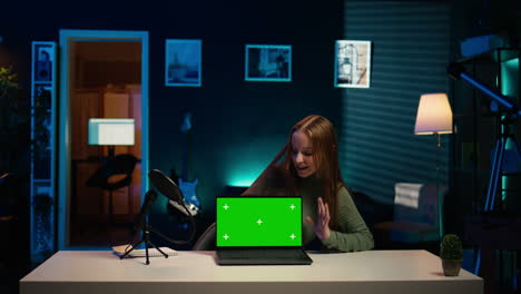 un joven artista presenta una computadora portátil de pantalla verde desde el video de patrocinio de la marca