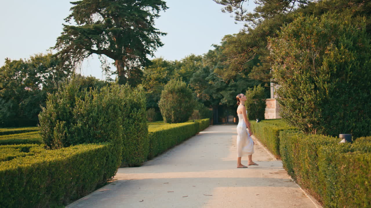 주말에 공원을 찾는 걸어다니는 여자. 아름다운 정원을 산책하는 여인