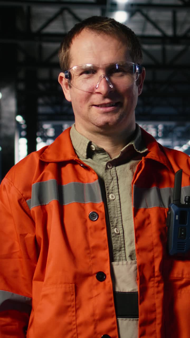 Vertical Video Portrait of industry worker on factory floor surrounded by machinery
