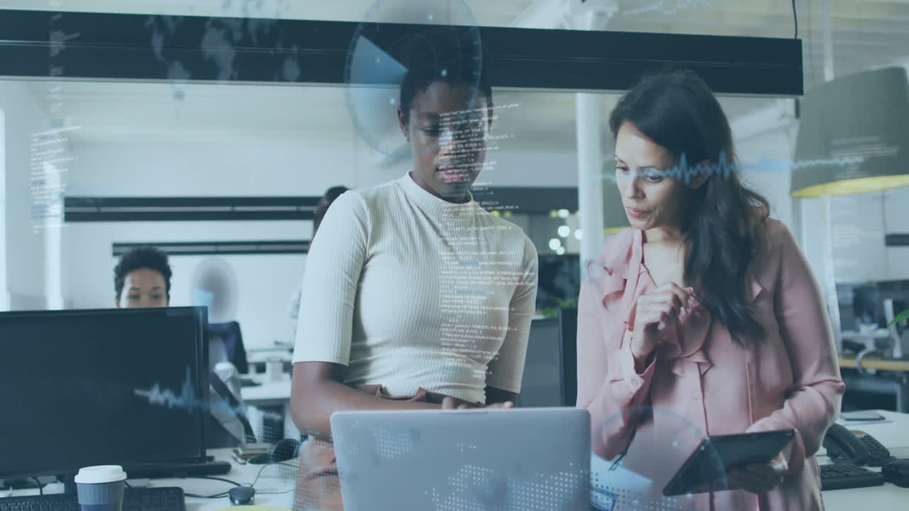 Two women collaborating at office desk with digital data overlay animation