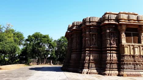 una paloma vuela desde el exterior intrincadamente tallado y los pilares de la parte trasera del templo del sol modhera