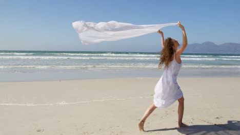Woman-running-by-the-sea-with-awaving-scarf.at-beach-4k