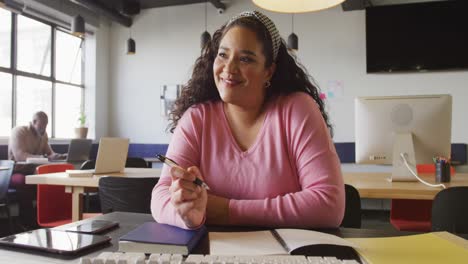 Portrait-of-happy-biracial-businesswoman-looking-at-camera-at-office
