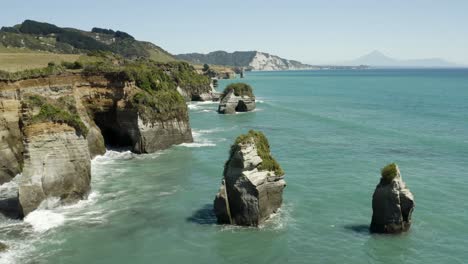 Toma-Aérea-Del-Paisaje-De-Islas-Y-Acantilados-En-La-Costa-De-Nueva-Zelanda