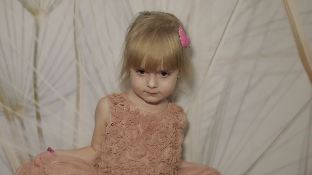 feliz niña de tres años hacer caras y bailar. niño rubio lindo