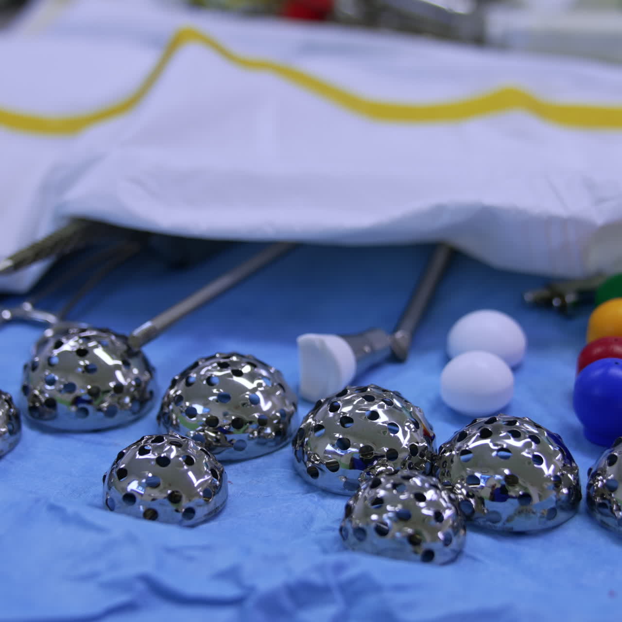Acetabular reamer of stainless steel on the surgical stand. Doctor takes one of the items. Close up. Orthopedic equipment and materials in surgery room