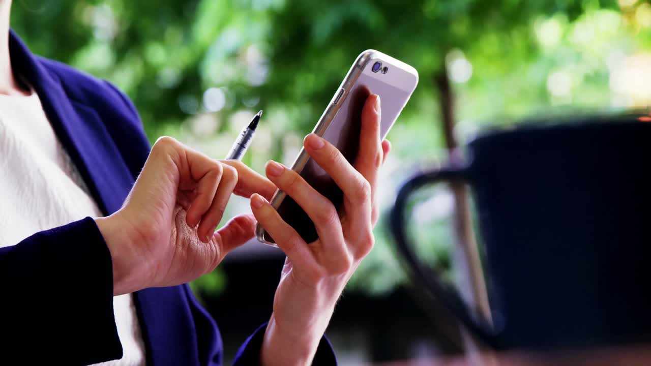 카운터에서 휴대폰을 사용하는 여성 고객