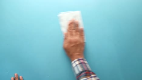 person cleaning a surface with a tissue