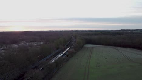 drone footage of a morning train arriving at a village train station in england