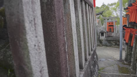 santuario fushimi inari, empuje cercano a lo largo de la cerca de piedra del templo, kyoto japón