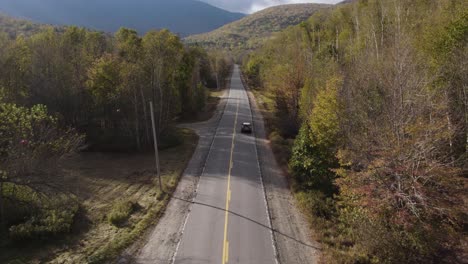 conducción panorámica por una carretera de asfalto a través del paisaje rural en el parque estatal grafton notch en maine, ee.