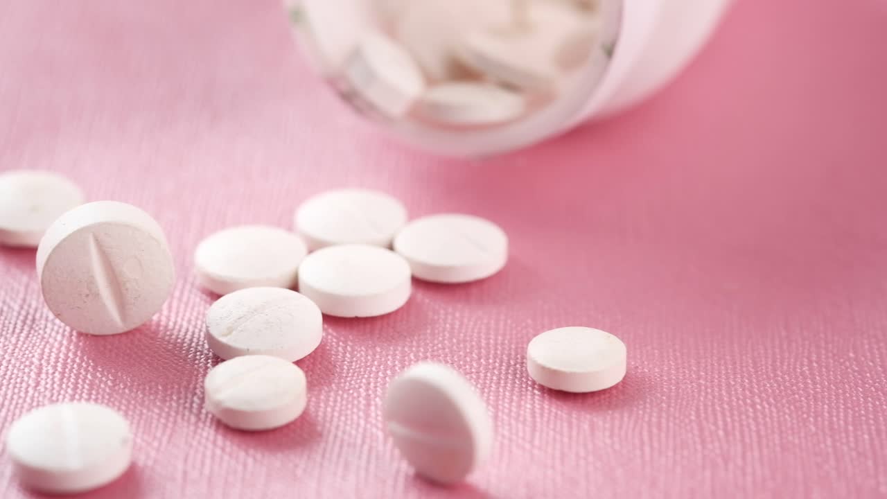 분홍색 표면에 색 알약