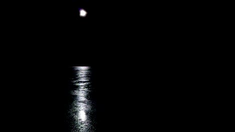 aerial, full moon and moonlight shine with reflection mirrored on ice, drone shot sideways