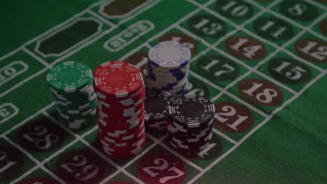 Animation-of-white-confetti-over-poker-chips-on-gambling-table