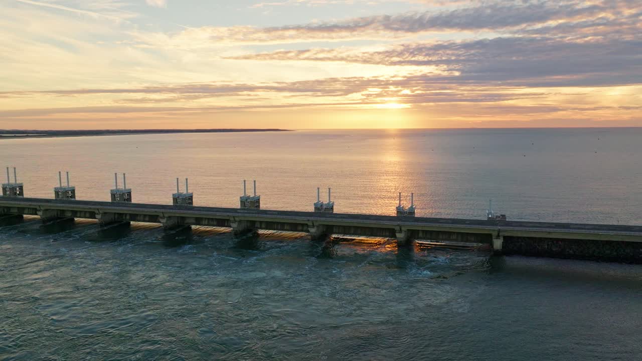 해가 지는 동안 오스테르데 폭풍파 장벽의 드러난 드론