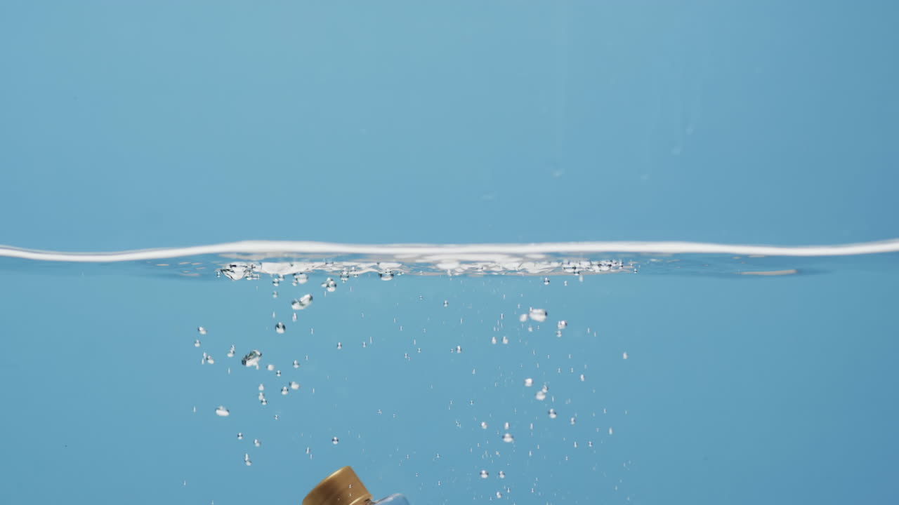 파란색 배경에 복사 공간과 함께 물에 벽을 는 아름다움 제품 병의 비디오