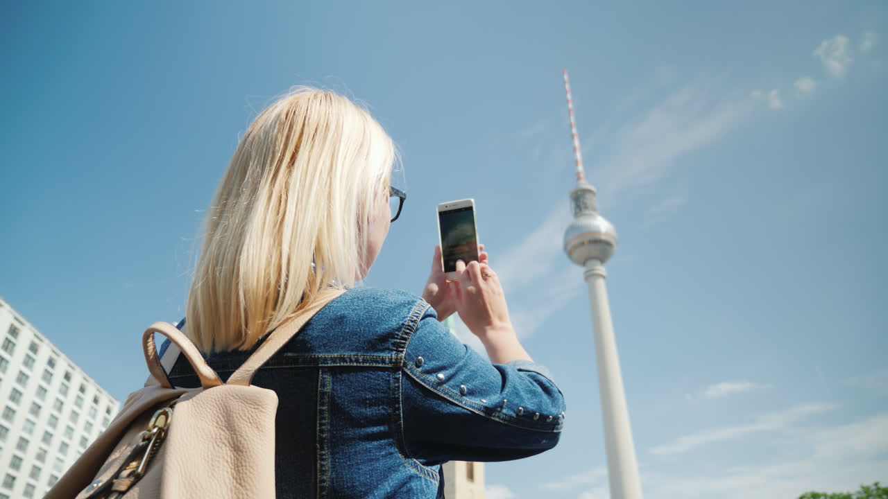 여자는 베를린 tv 타워의 사진을 찍는다