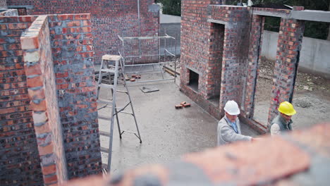 construction site with engineers inspecting brickwork
