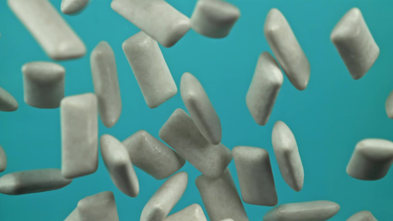 Muitos pedaços de chiclete branco flutuando em fundo azul.