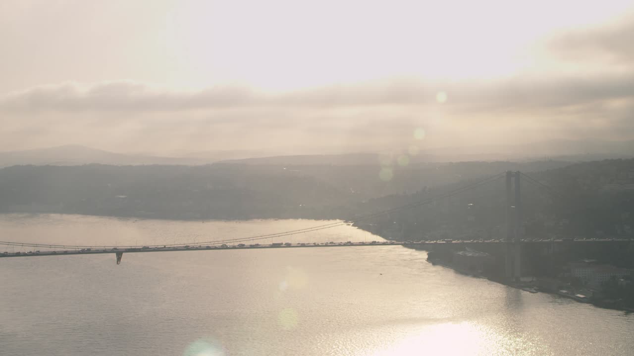 보스포루스 (bosphorus) 에 있는 다리와 해가 지는 동안 그 위에 있는 자동차.