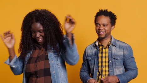 Lovely-cheerful-husband-and-wife-dancing-around-in-the-studio-and-having-fun