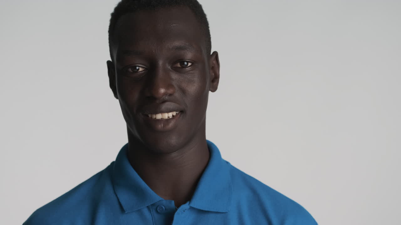 un hombre afroamericano con un fondo gris.