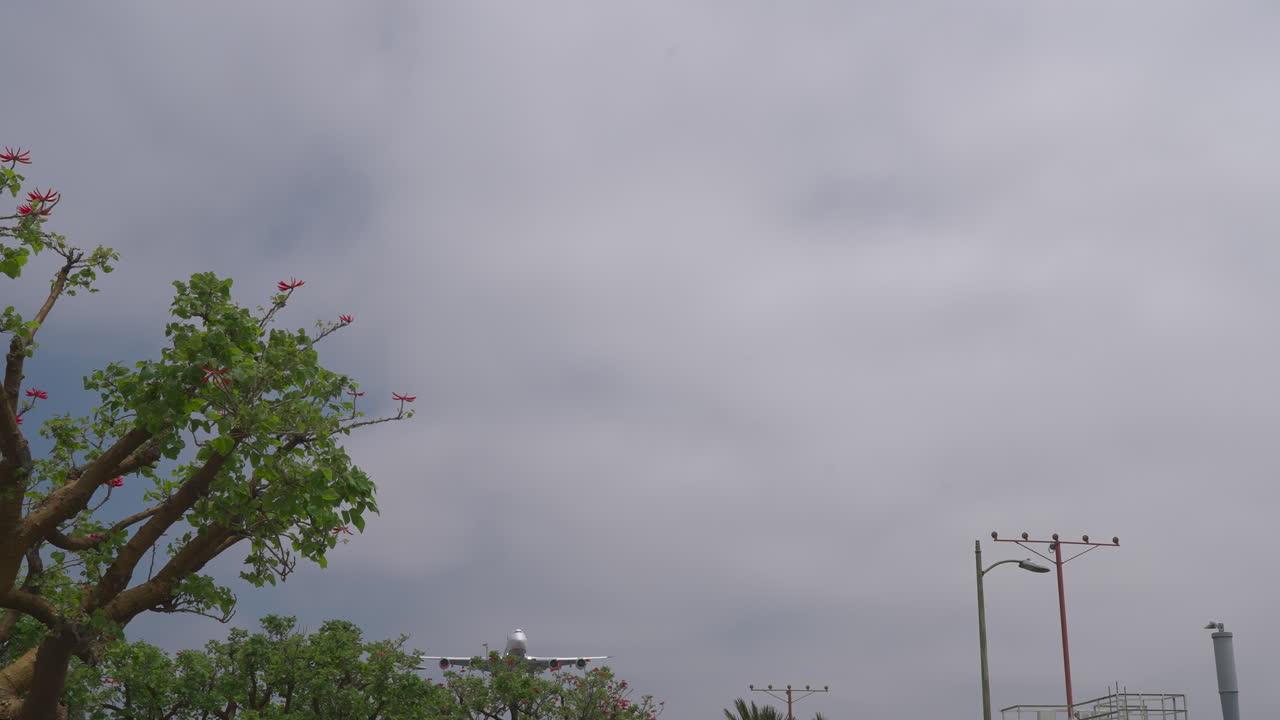 A Boeing 747 airliner seen over approach lights landing at Los Angeles International Airport in slow motion