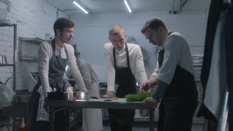 chefs in a kitchen discussing food preparation