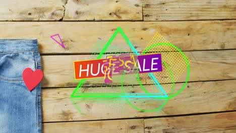 animation of huge sale text over denim trousers on wooden background