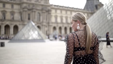 mujer frente al museo del louvre en parís