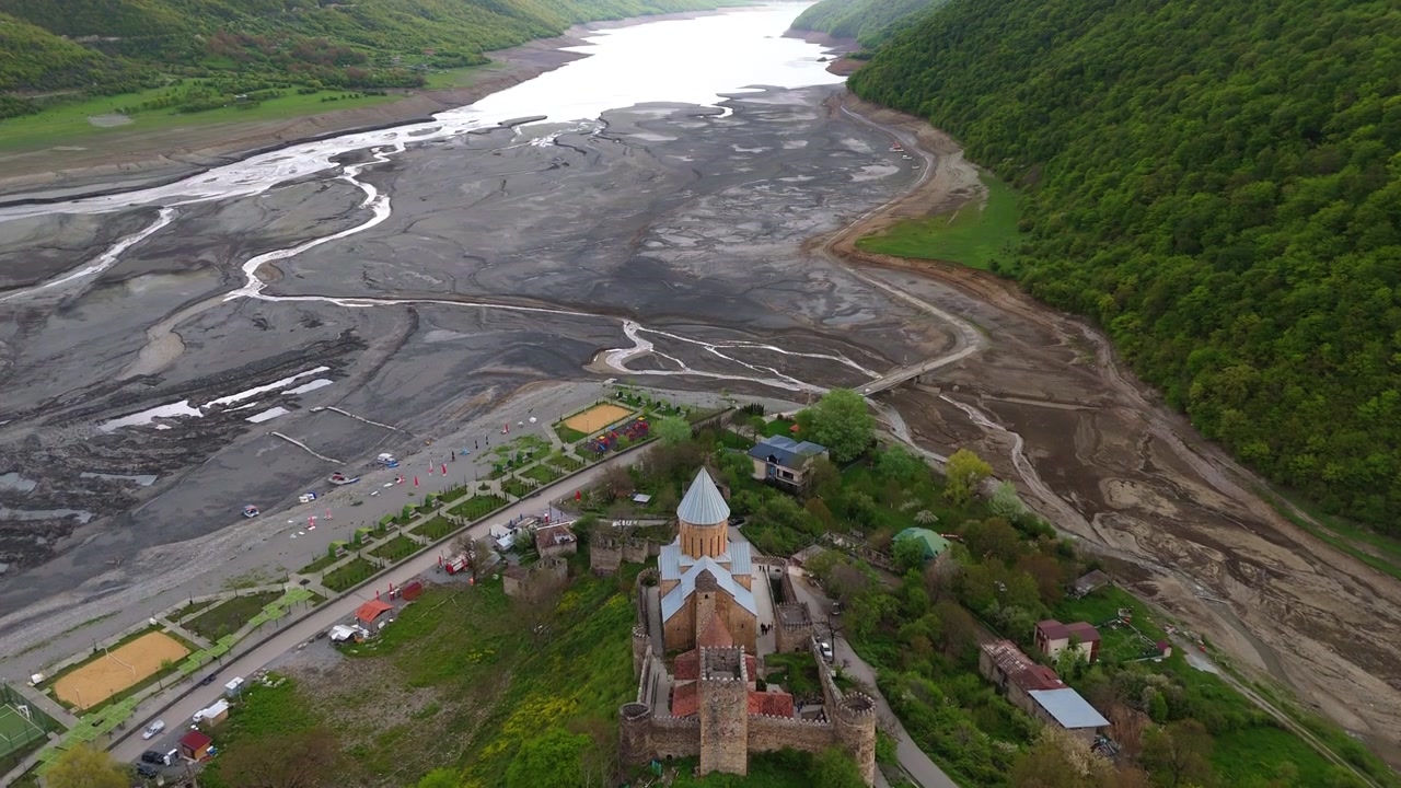 Gün batımında Ananuri Kalesi ve Aragvi nehri vadisinin drone çekimi. Gürcistan dağlarındaki ortaçağ tahkimatı ve dini kompleksinin çarpıcı bir görünümü.