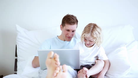 Lächelnder-Vater-Und-Sohn-Schauen-Auf-Einen-Laptop