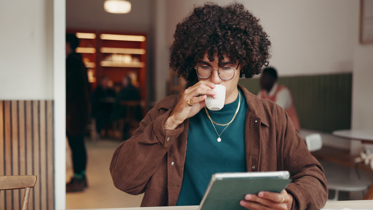 Uomo che usa il tablet in un caffè