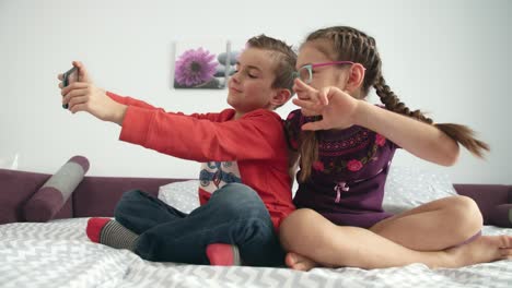 niños tomando fotos en el teléfono móvil en casa. amigos tomando selfies en el teléfono inteligente