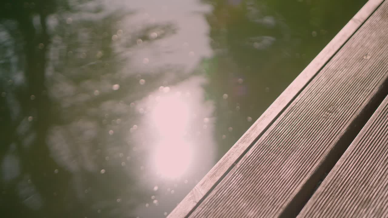 목재 부두 옆 수면에 반사되는 햇빛과 눈부심