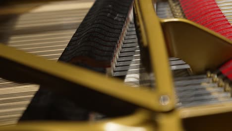 closeup of an inside of a piano hammers hitting strings in 4k