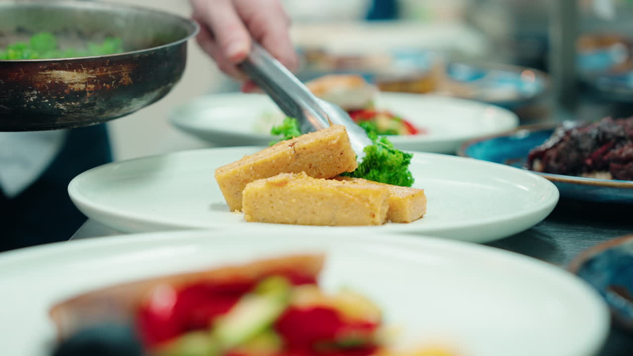 Close up slow motion shot of food courses being prepared and assembled at the restaurant kitchen.
