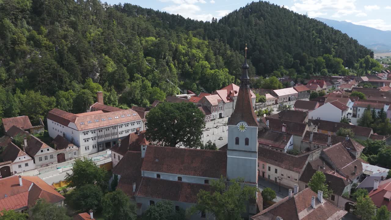 Aerial drone approaching the Evangelical Church of Râșnov, highlighting historic architecture and the surrounding town