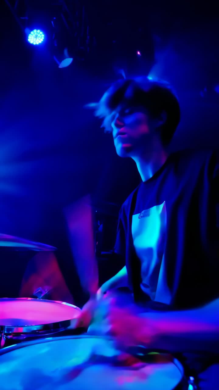 Drummer performing on stage with vibrant lighting