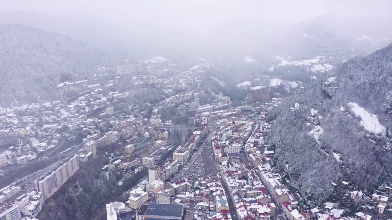 Spectacular aerial of snowing in small historic town of Saint-Claude, Jura. Winter cityscape, France