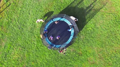 group of kids jumping on trampoline during vacation trip on farm during summer