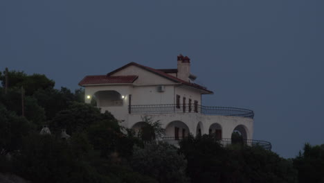 Vista-Nocturna-De-La-Cabaña-En-La-Colina-Verde.