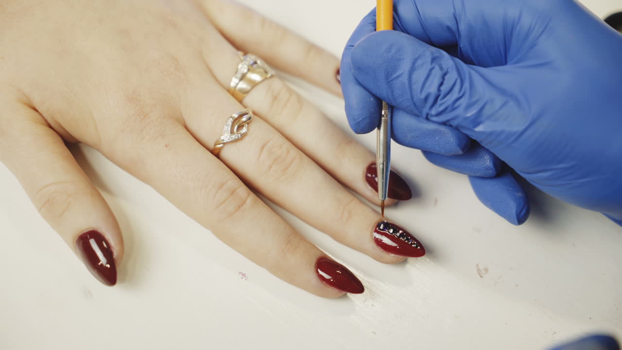 Nail care and manicure. Manicure hand painting of the client's nails. Nail care.