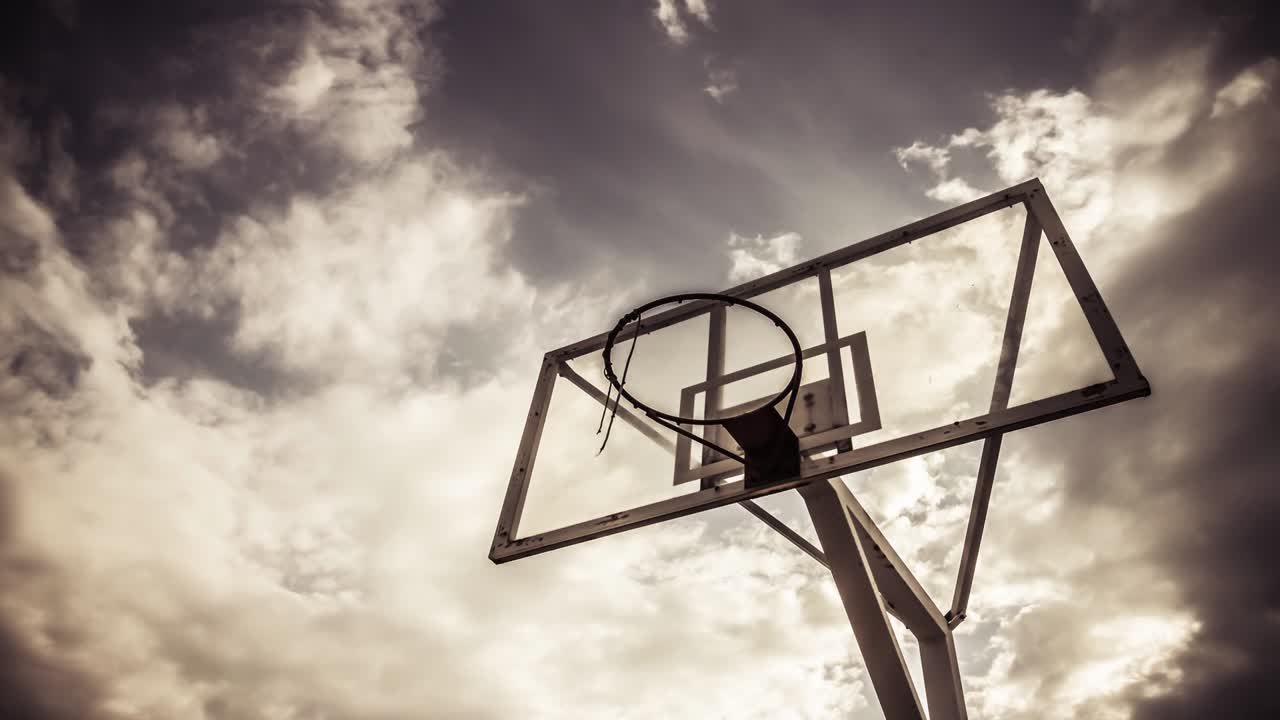 el fondo de la nube dramáticamente en movimiento de un anillo de baloncesto en color cálido