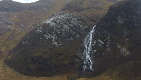 aerial view of steall waterfall in dramatic weather with rainfall - glen nevis valley, scotland