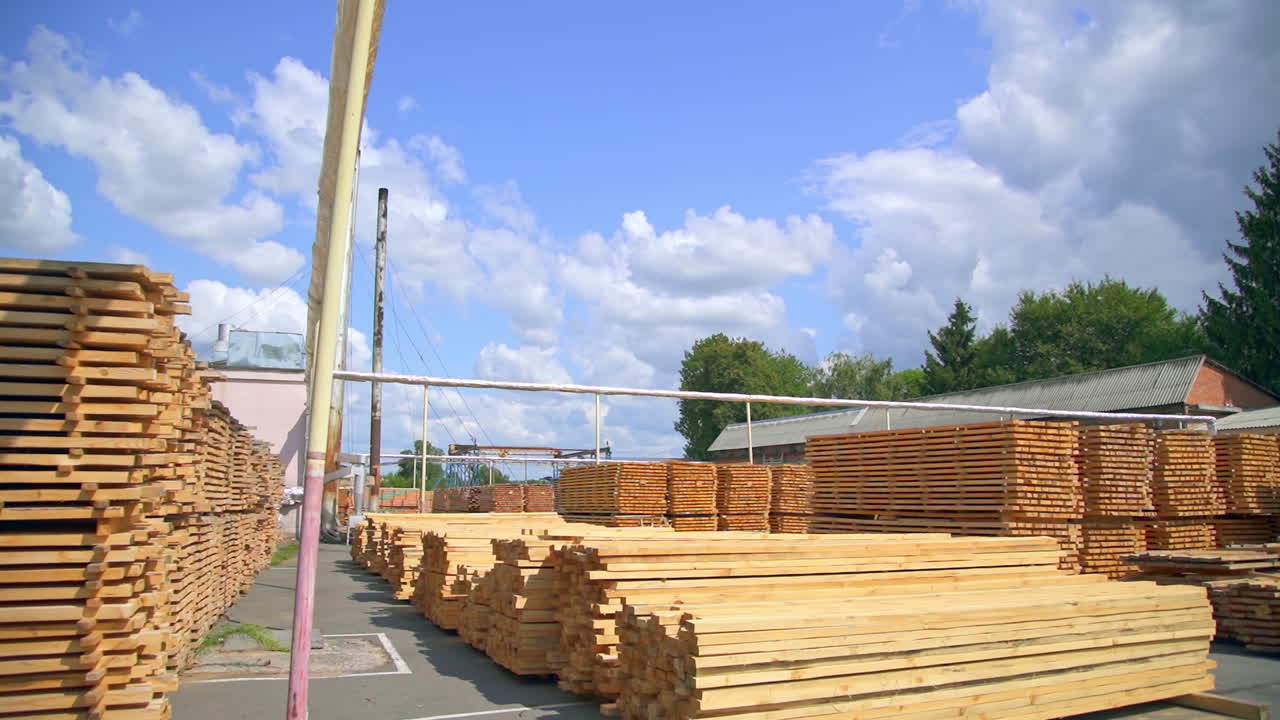 Numerous piles of timber bars stored outdoors. Stacks of wooden sticks are kept for future processing at plant.