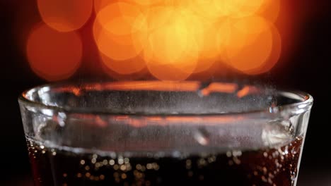 Cola-with-splashing-bubbles-slow-motion-on-a-blurry-light-,blurry-background.